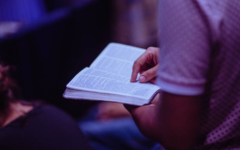 A person holding an open book in their hands.